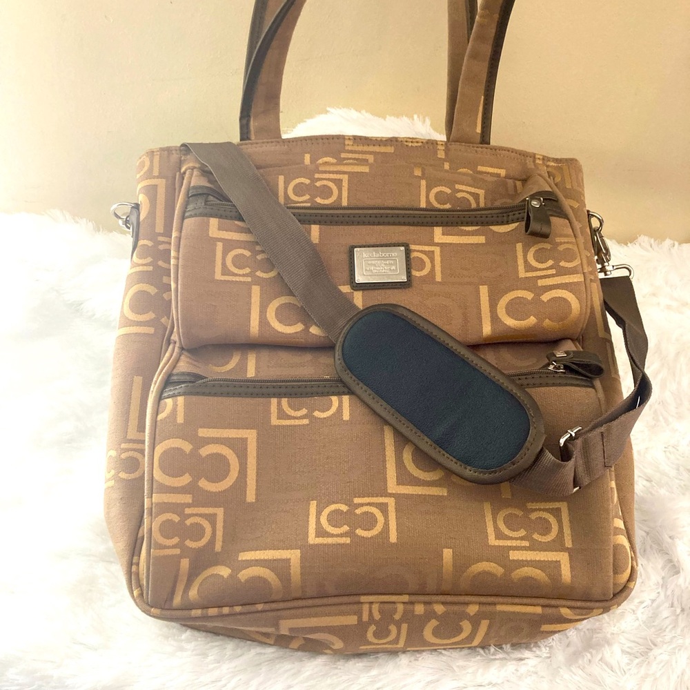 Liz Claiborne Rand . Bag is ready for a home, pattern logo, color tan .